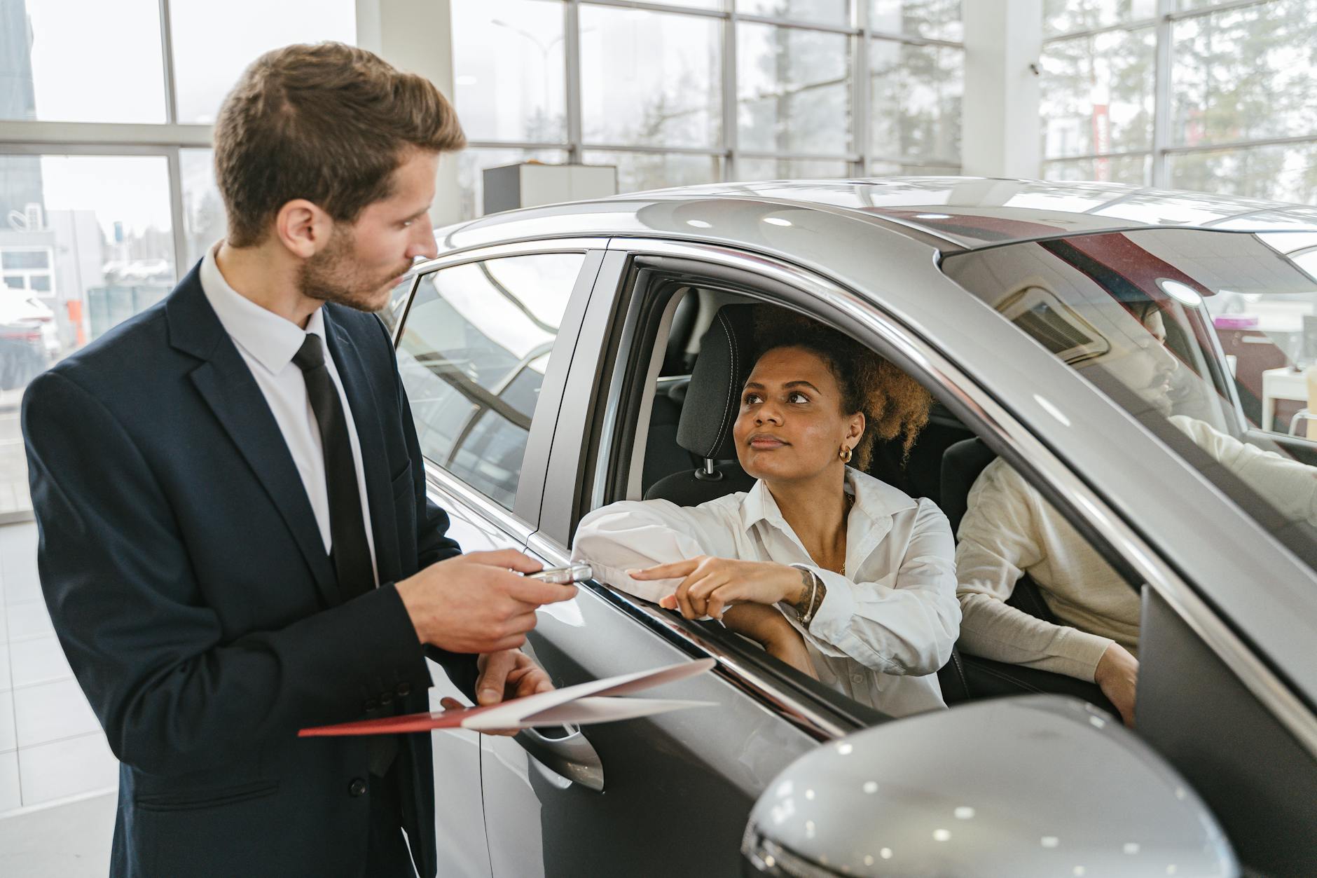 Photo by Antoni Shkraba on <a href="https://www.pexels.com/photo/car-dealer-handing-in-keys-to-a-woman-sitting-in-a-new-car-7144174/" rel="nofollow">Pexels.com</a>