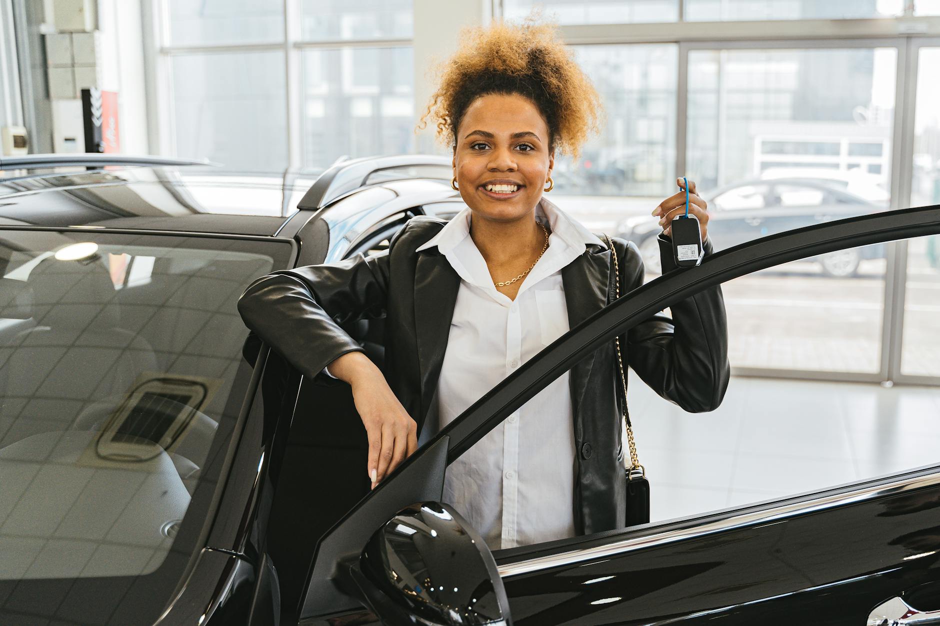 woman in black blazer holding car keys smiling